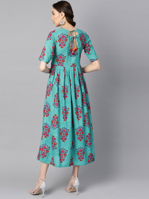 Turqish blue color printed half sleeve pleated maxi dress with deep back and tassel detailing.